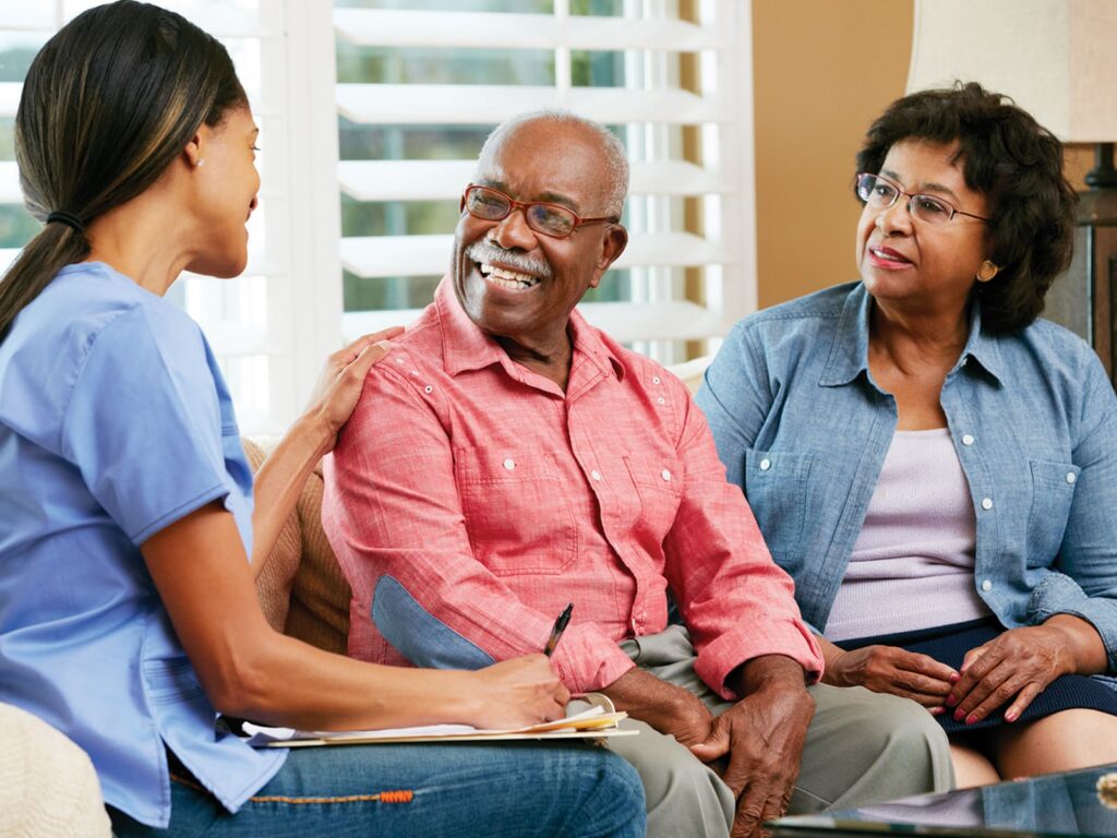 Woman with clipboard meeting with elderly couple.